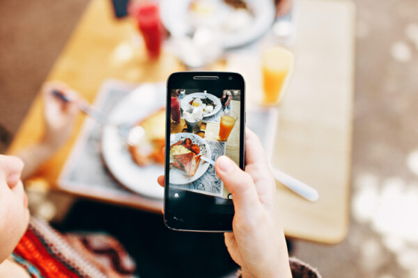 Person snapping photo of food porn with phone