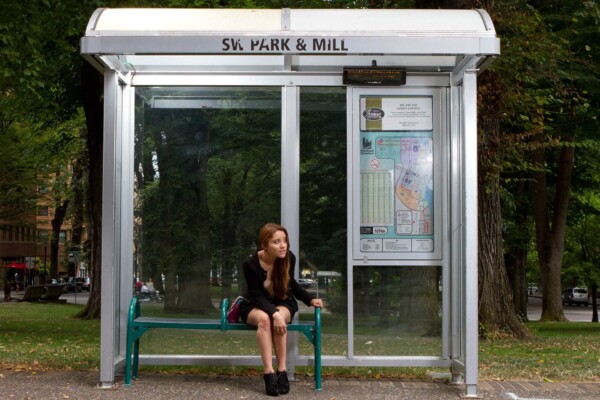Woman sitting at bus stop