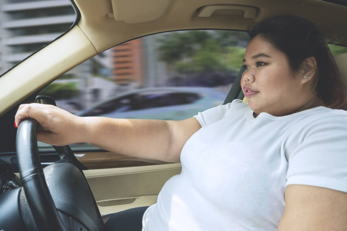 Obesity: Overweight or obese woman driving car