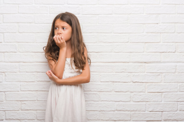 Young anxious girl biting her nails