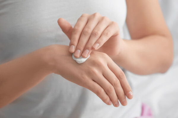 Woman applying hand cream, moisturizer on skin