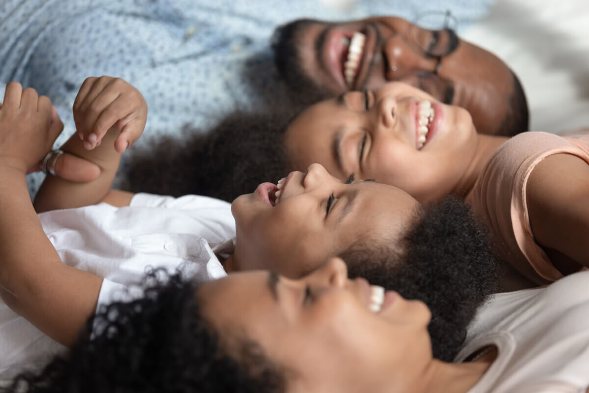 Close up of happy family relax on bed together