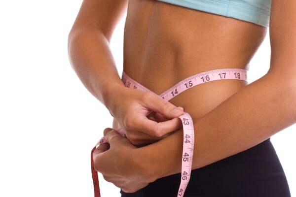 Weight loss: woman measuring her waist size