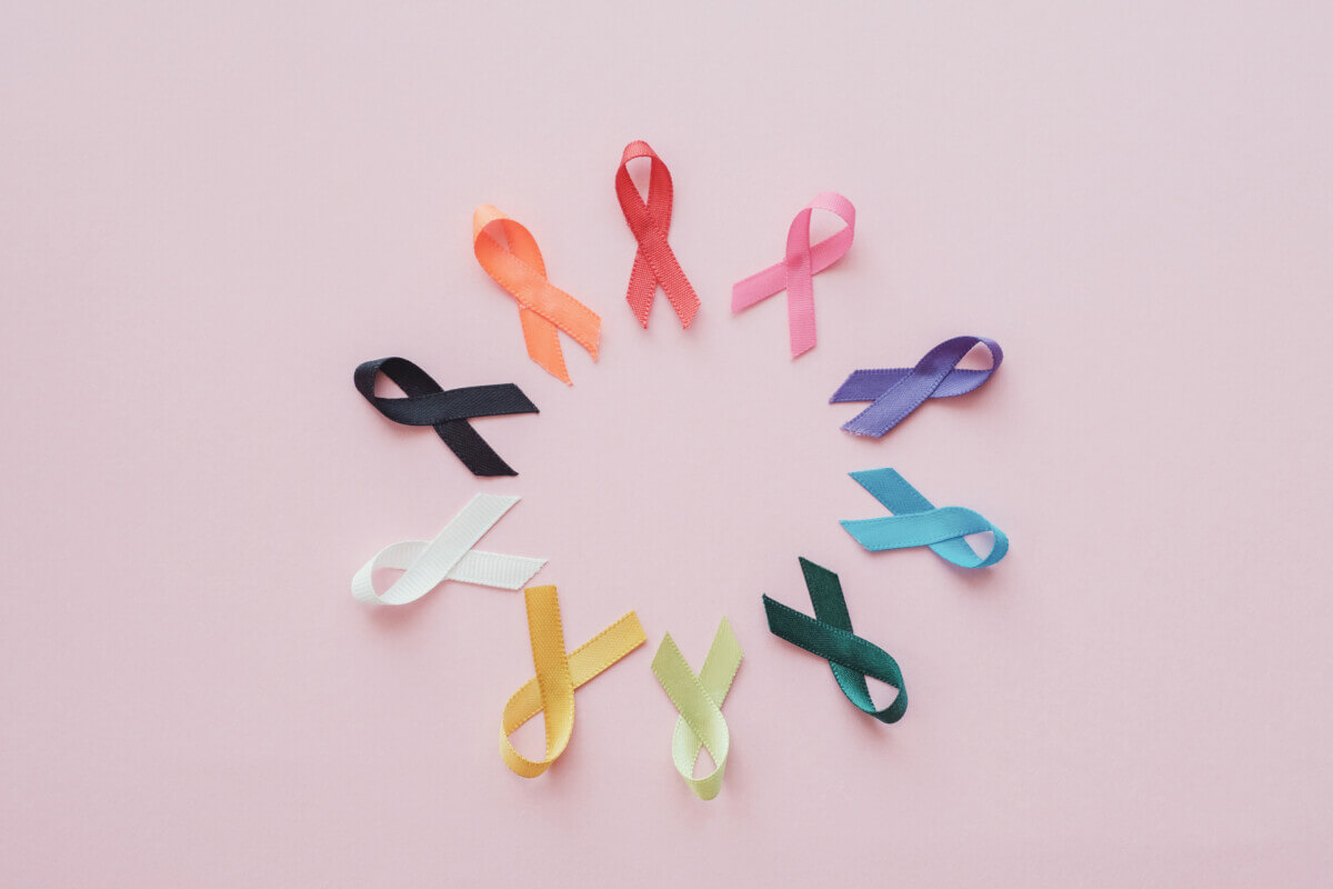 Cancer ribbons on pink background, cancer awareness, World cancer day, National cancer survivor day, world autism awareness day