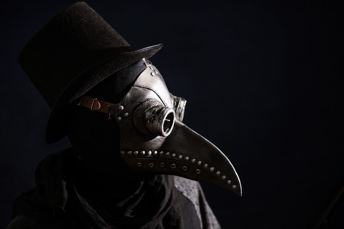 Masked man Bubonic plague doctor, head profile, with bird mask and hat. Vintage style. Biohazard concept.