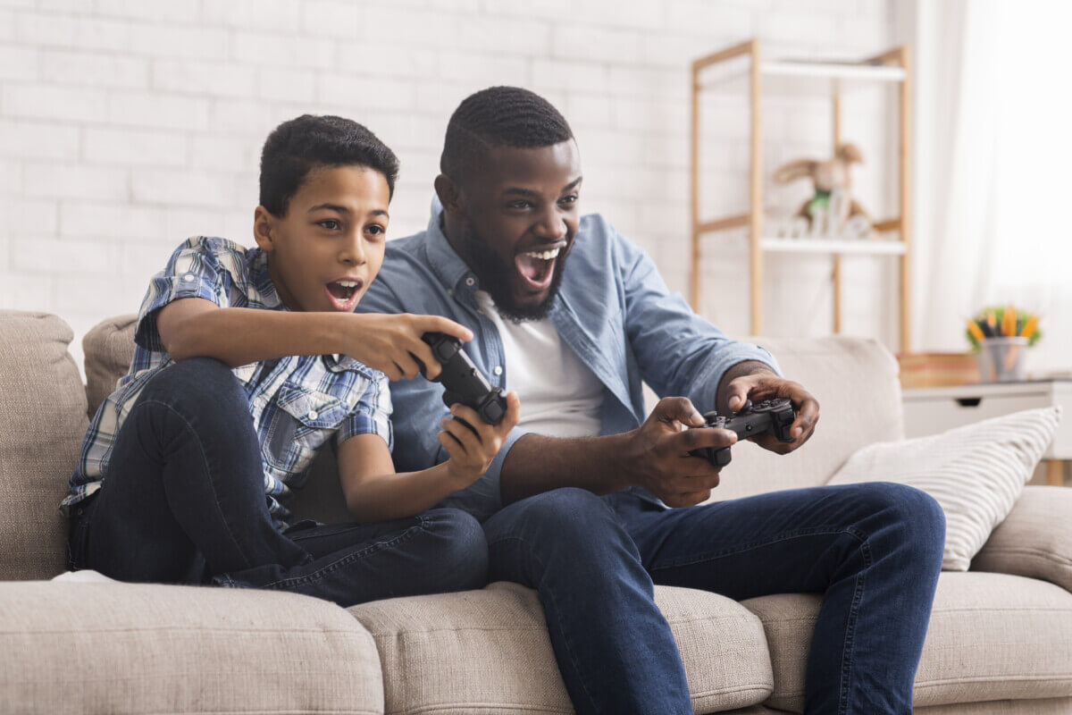 Cheerful Father And Son Competing In Video Games At Home