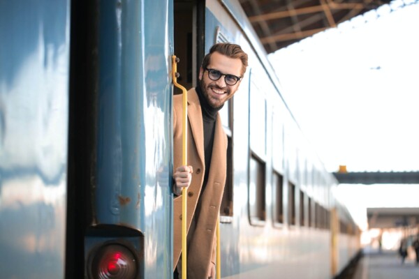 Man smiling while getting off a train