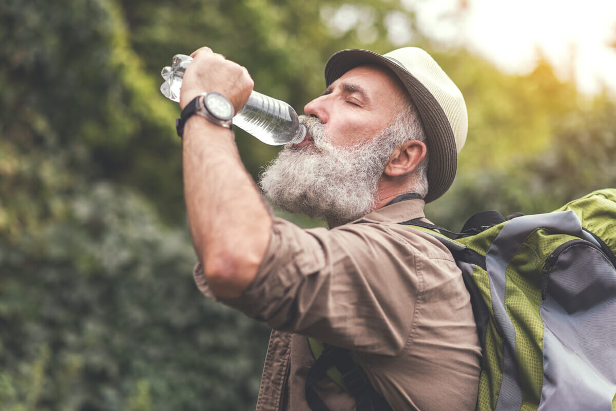 Senior male hiker is very thirsty
