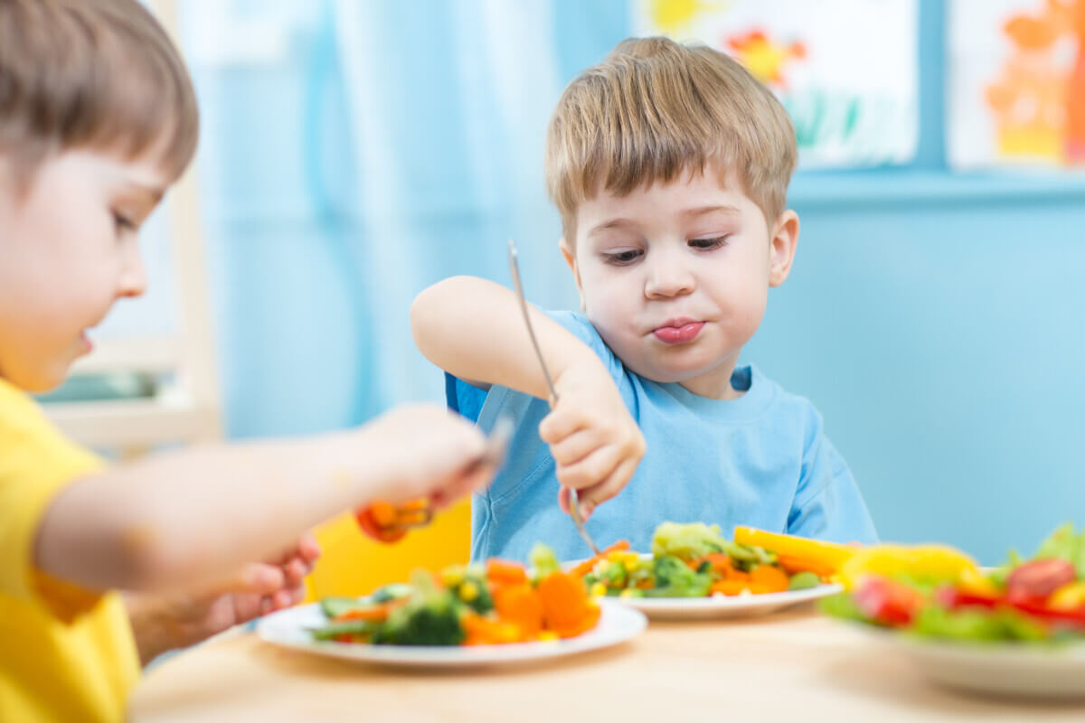Children eating vegetables in kindergarten or at home