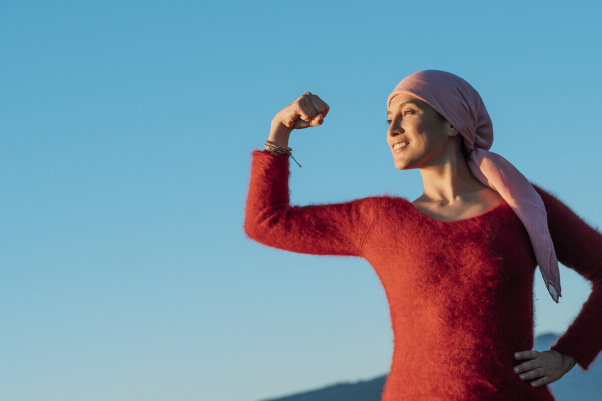 Healthy woman showing her fist of power against female cancer