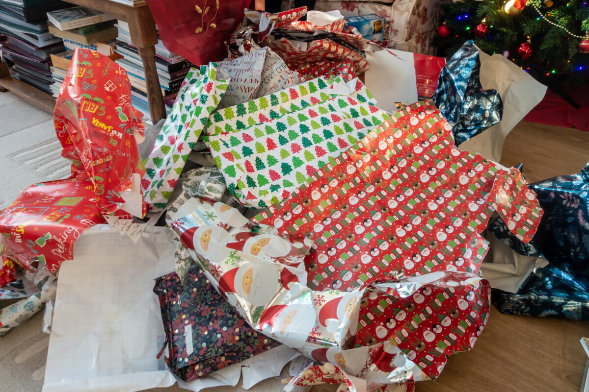 Piles of discarded Christmas wrapping paper left on the floor af