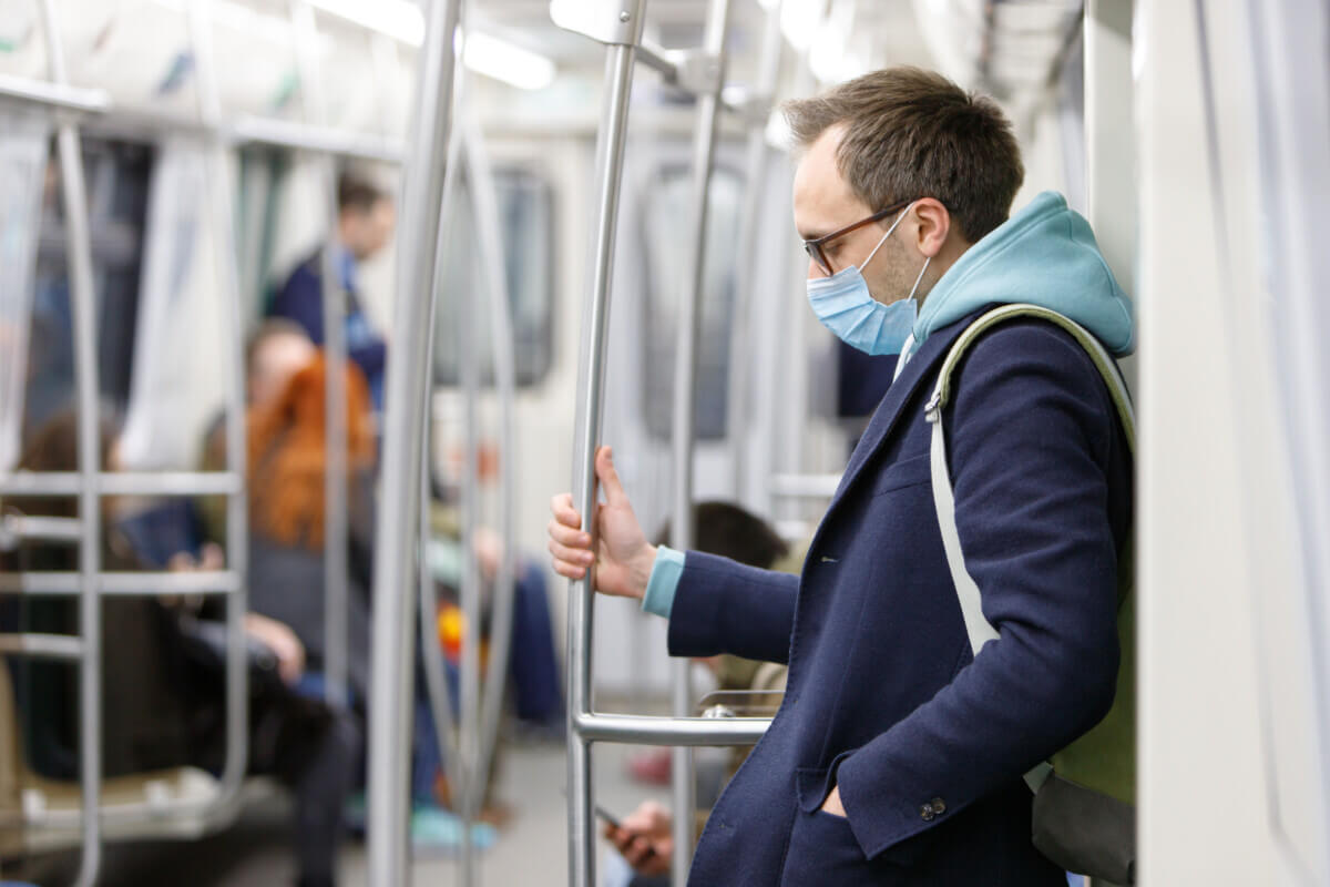Man on subway in face mask during COVID