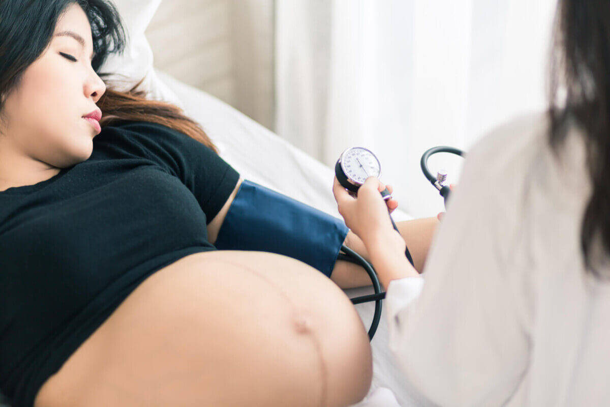Female Obstetrician doctor measuring blood pressure of the preg