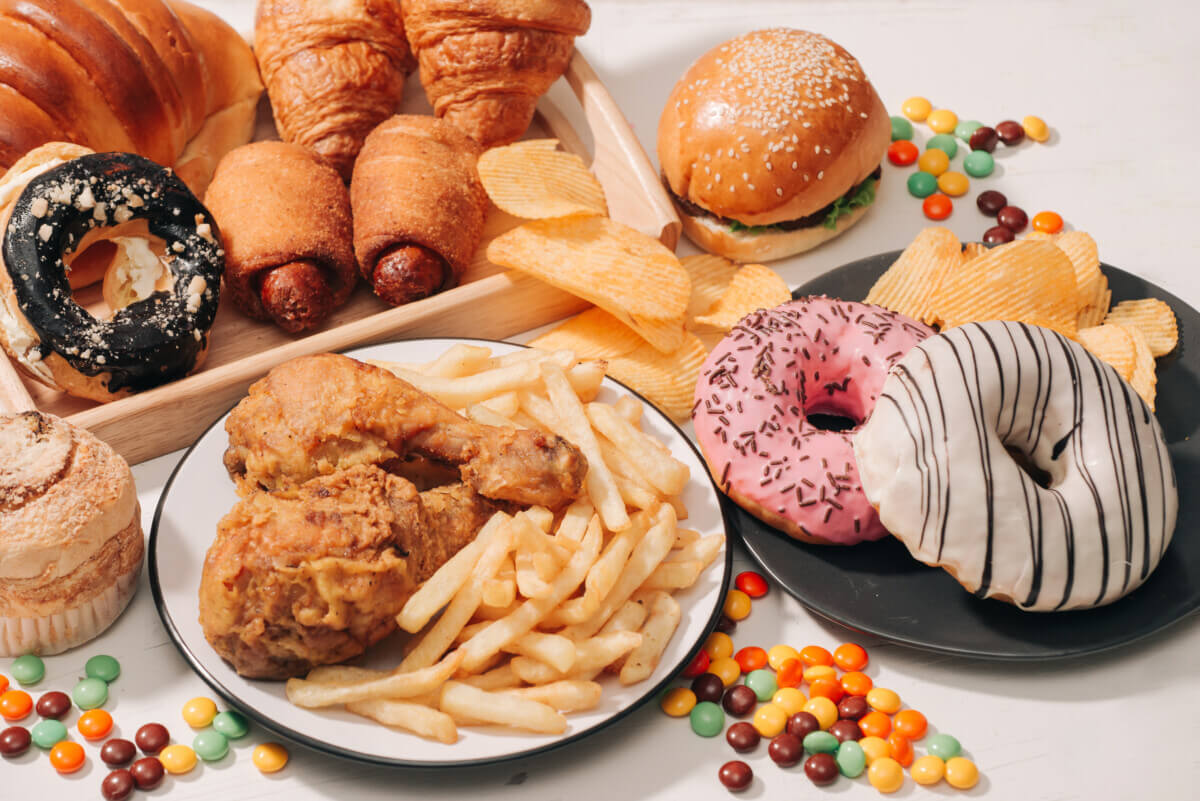 Fast food and unhealthy eating concept - close up of fast food and sugary drinks