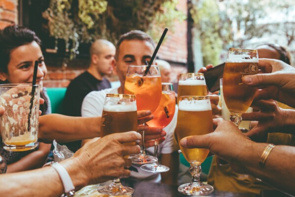 Friends toasting beer and alcohol at bar