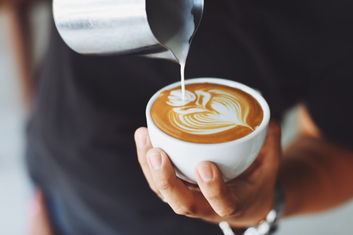 Barista pouring coffee latte