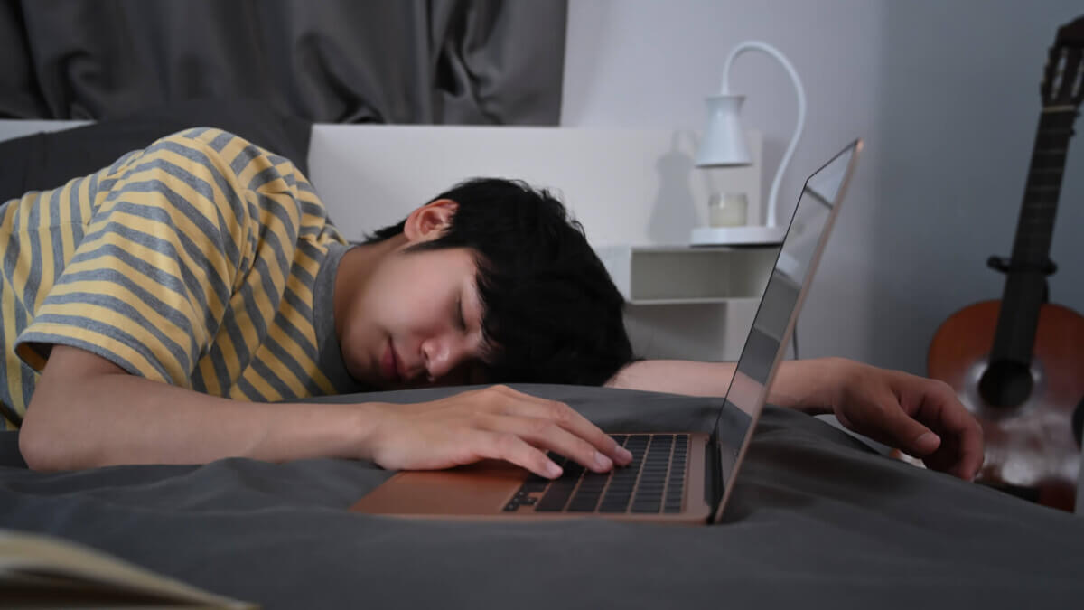 Teen asleep next to laptop