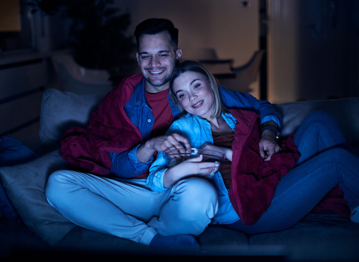 Couple having movie night at home on the couch.