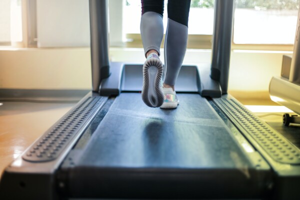 Woman getting exercise at gym by running on treadmill