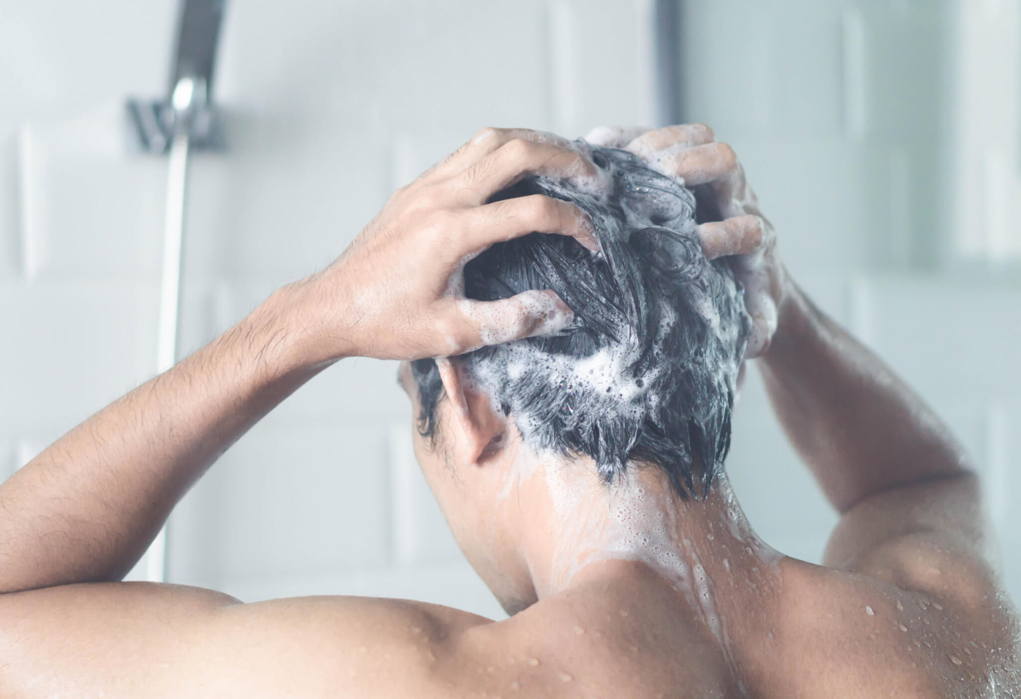 Man shampooing his hair in the shower