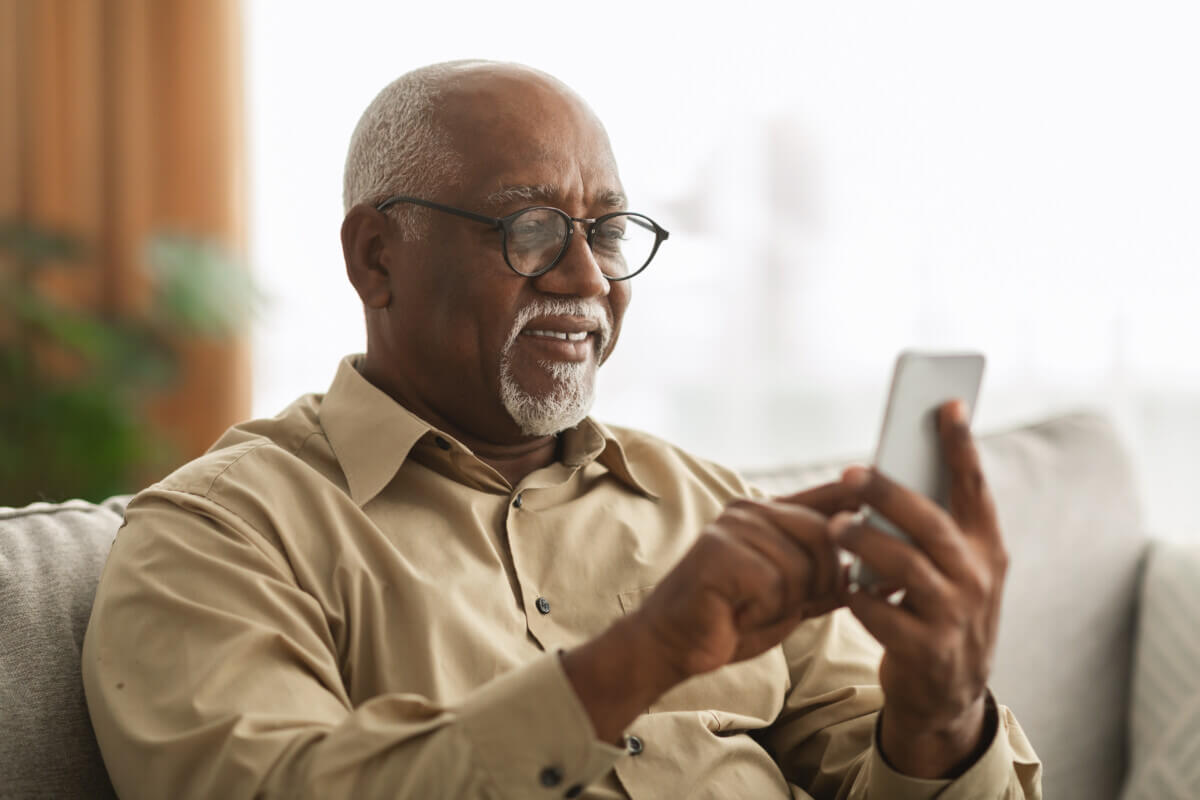 Older man sending a text message on his smartphone