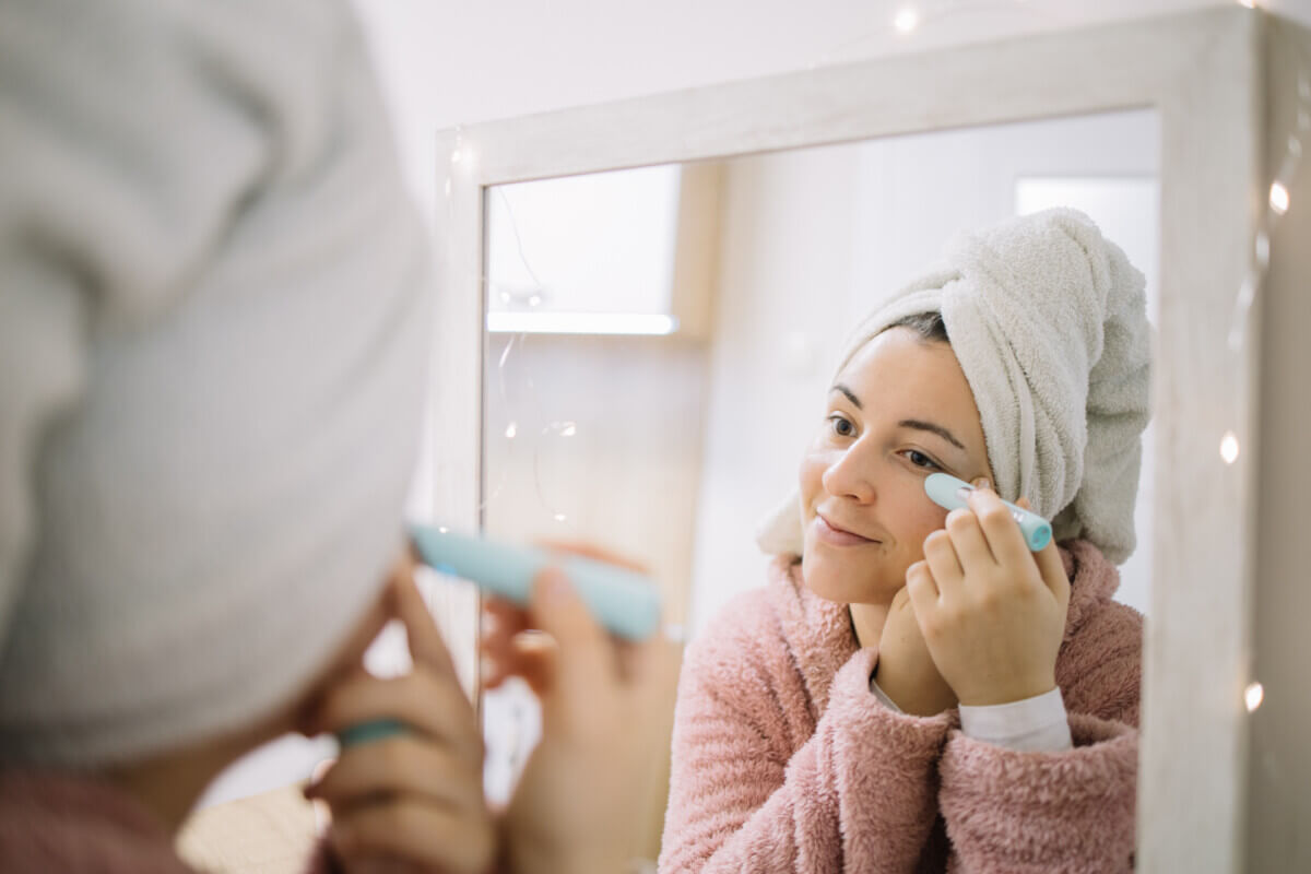 Woman using wrinkle eraser while looking at herself in the mirror