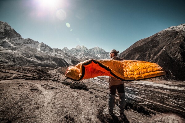 Man holding a sleeping bag on a mountain