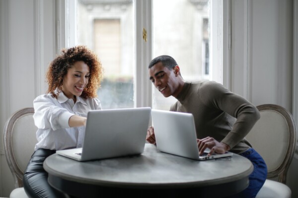 A man and woman working on their laptops at home