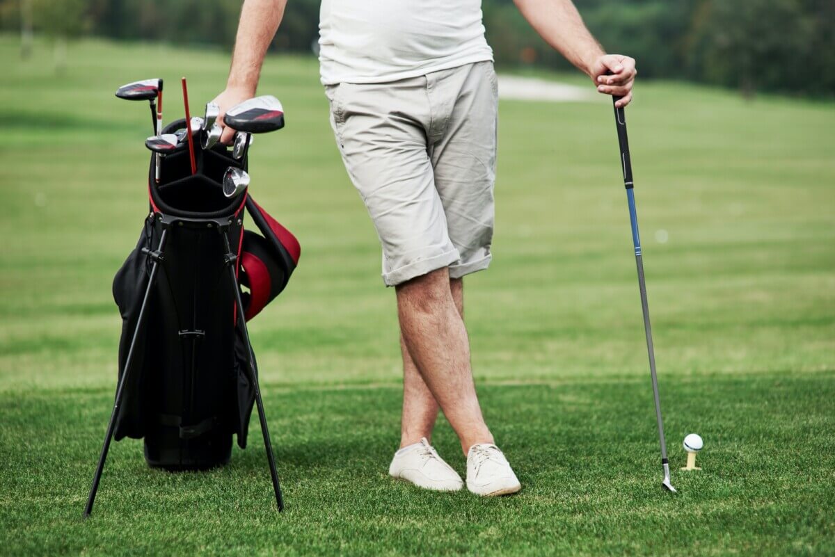 Golfer leaning on golf bag