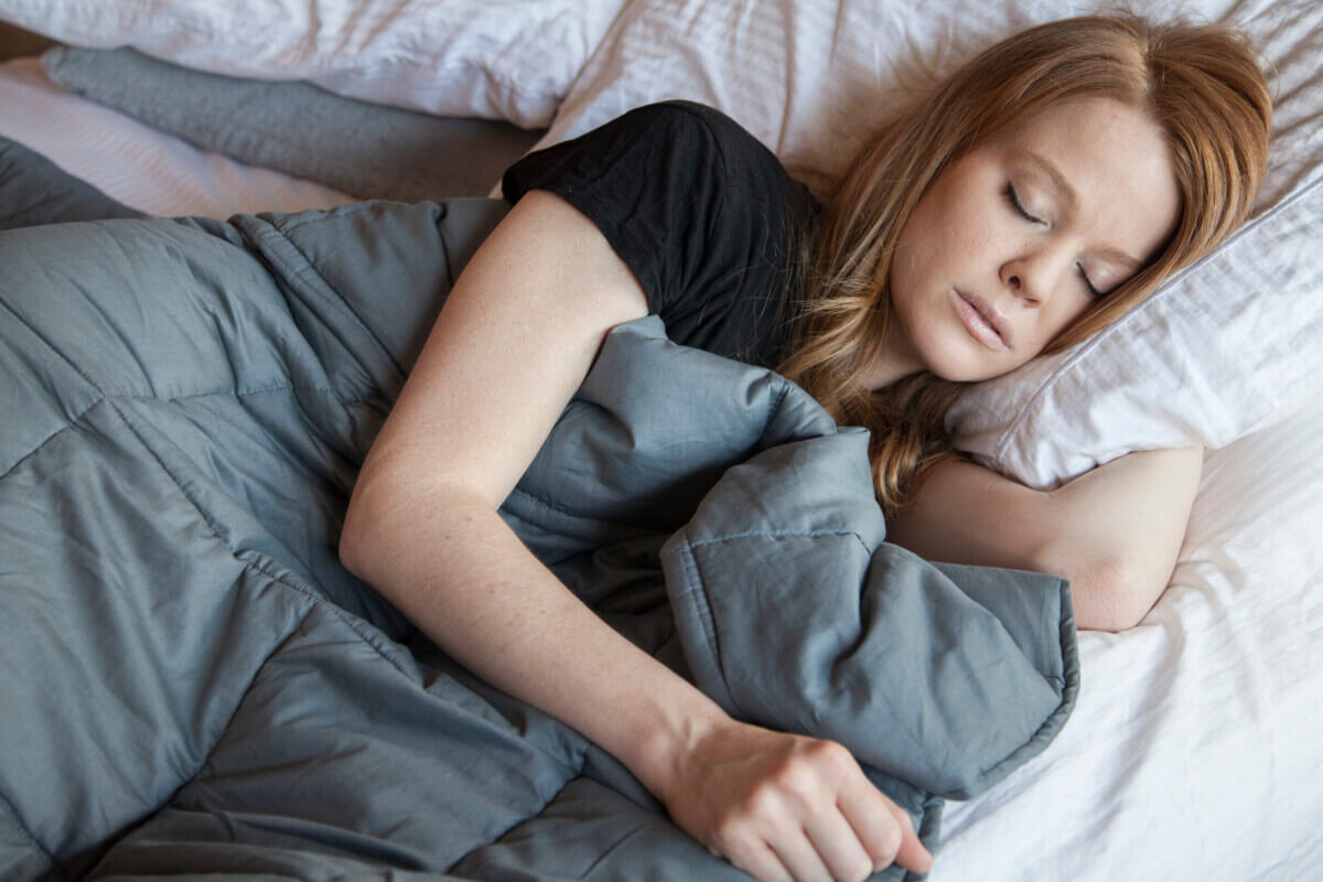 A woman sleeping with a heated blanket