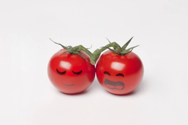 a pair of tomatoes with faces drawn on