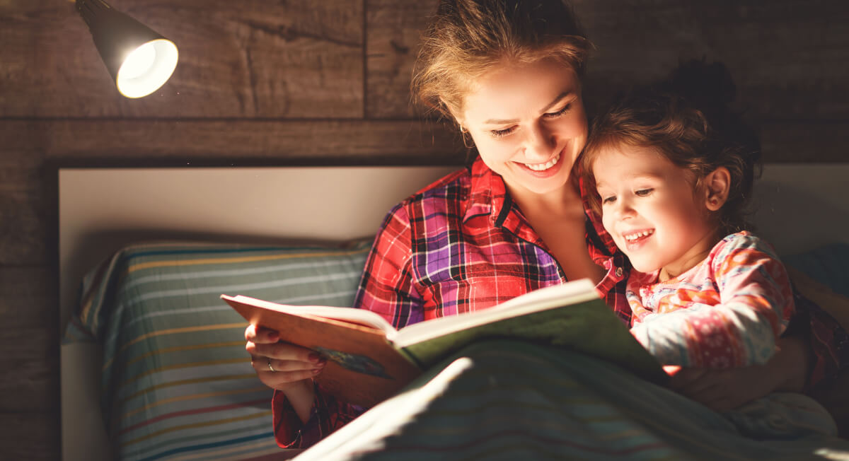 Mother reading to child in bed