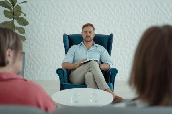 Therapist sitting with legs crossed during session with couple