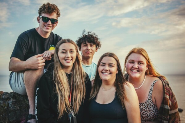 A group of teenagers smiling outside
