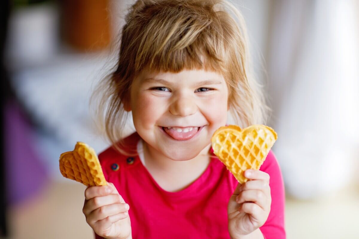 A little girl eating waffles
