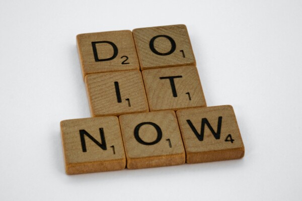 Scrabble tiles on white background spelling out "Do it now"