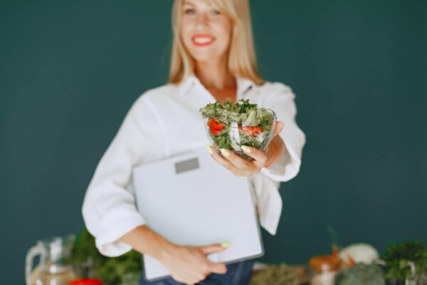 Woman Holding a Salad and Smiling 
