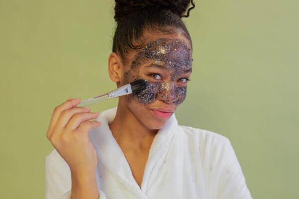 A woman applying a sparkly face mask