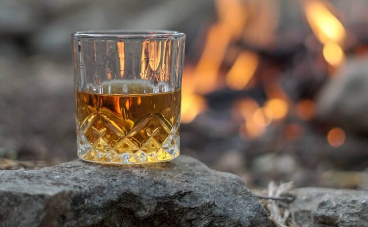 A glass of Scotch near a bonfire