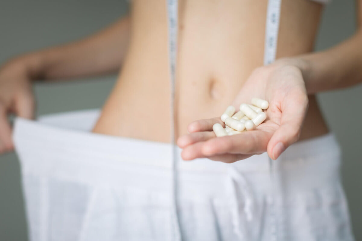 Woman holding weight loss pills