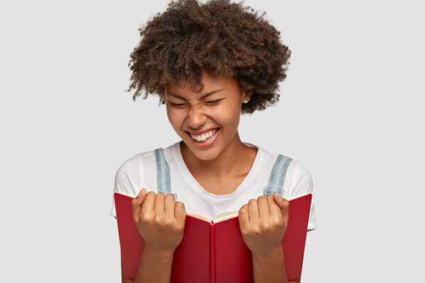 A teenager laughing at a book