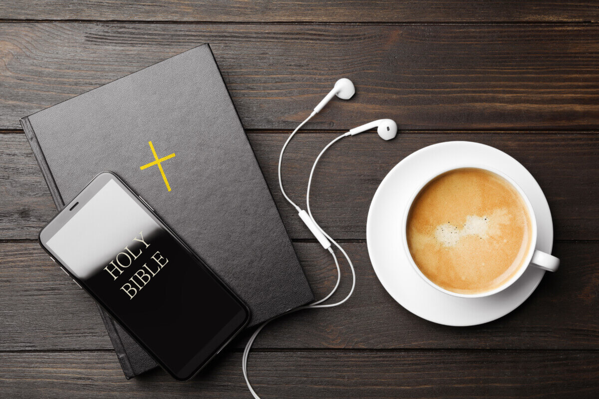 A Bible, cup of coffee, and Christian podcast