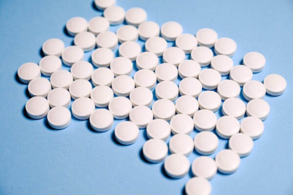 White aspirin Pills on Blue surface