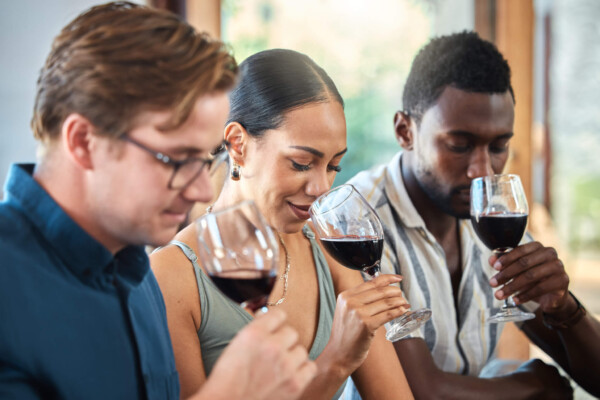 friends smelling wine at vineyard