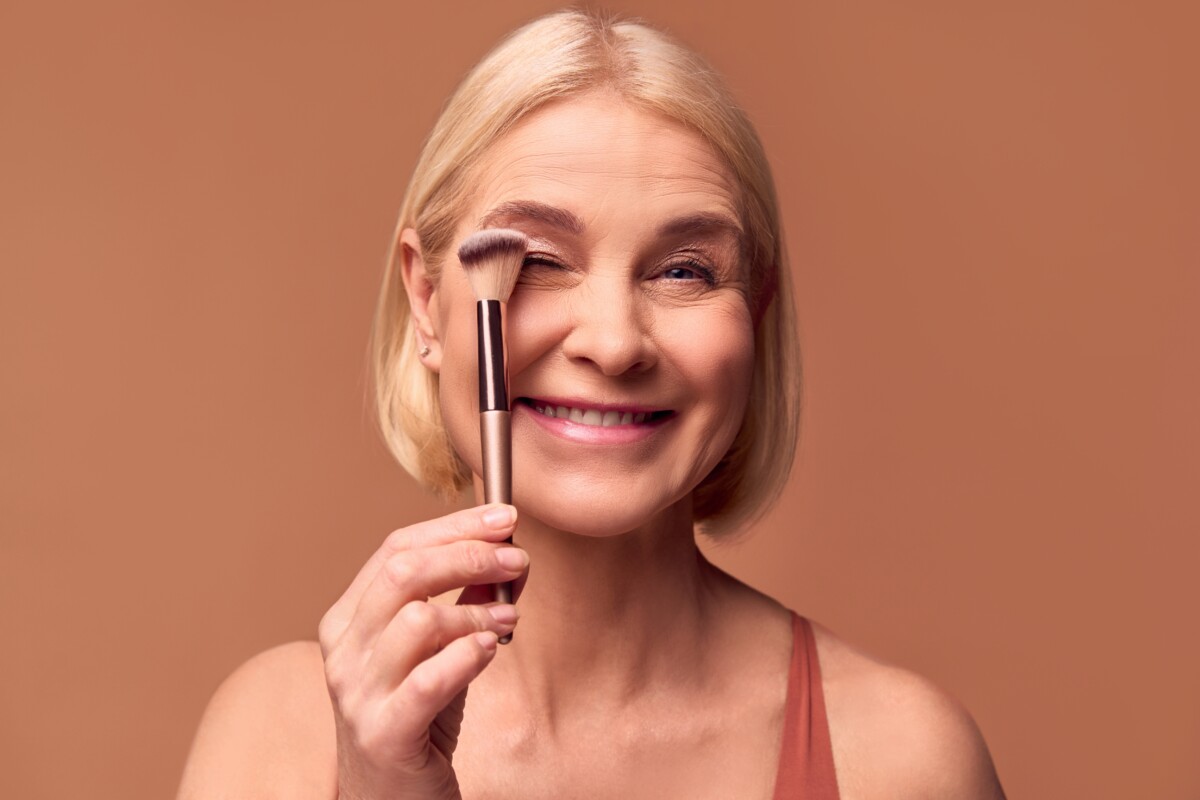 A woman holding a makeup brush