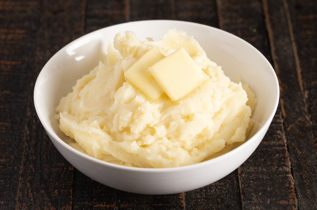 A bowl of mashed potatoes with butter