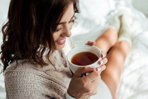 A woman drinking tea in bed