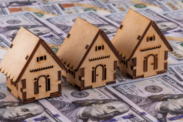 Housing affordability: 3 homes sitting on hundred dollar bills