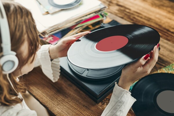Woman listening to vinyl album on record player