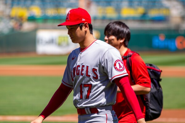 Los Angeles Angels DH Shohei Ohtani and translator Ippei Mizuhara walk on the field before a game against the Oakland Athletics at the Oakland Coliseum.